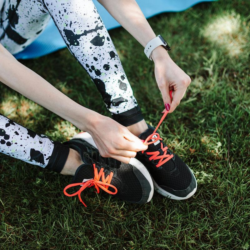 Close-up of a person's athletic shoes on a yoga mat, ready for a workout.
